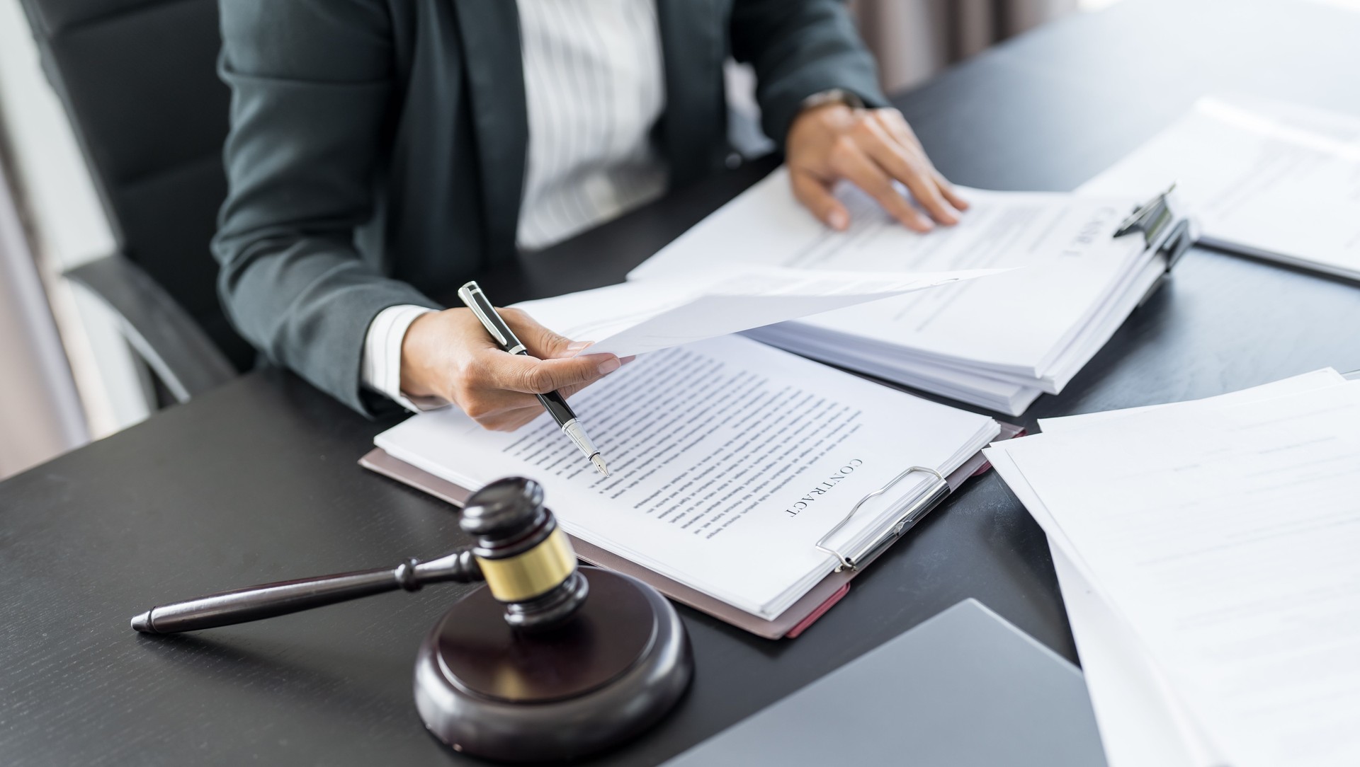 Lawyer businessman workingÂ with lawbook in officeÂ or courtroom Legal counsel with gavel and legal law. justice and lawyer concept Judge gavel hammer on Lawyer desk
